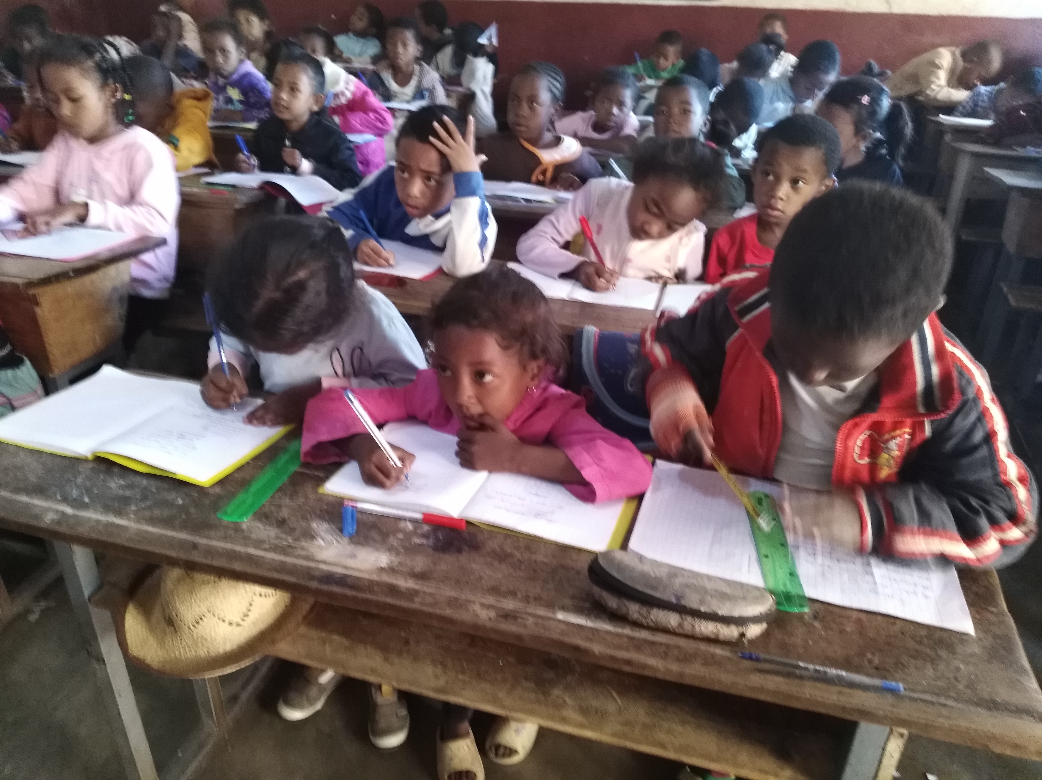 Élèves malgaches en classe lors de leurs devoirs scolaires soutenus par l'AFEM